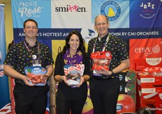 Brandon Burrell, Danelle Huber and George Harter with CMI Orchards show pouch bags of Kiku apples, American Dream cherries and Envy apples.